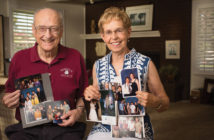 Trustee Emeritus Robert “Bob” Wiens ’56 and his wife, Marion ’57, hold photos of their scholarship recipients. (Photo by William Vasta)